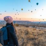 woman looking at hot air balloons in cappadocia